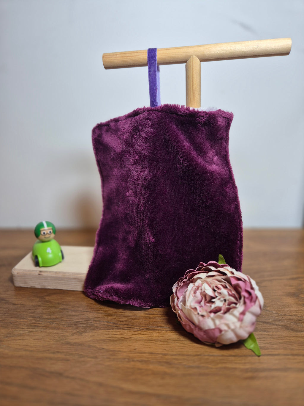 Plain side of fleece comforter on stand with flower and toy accent