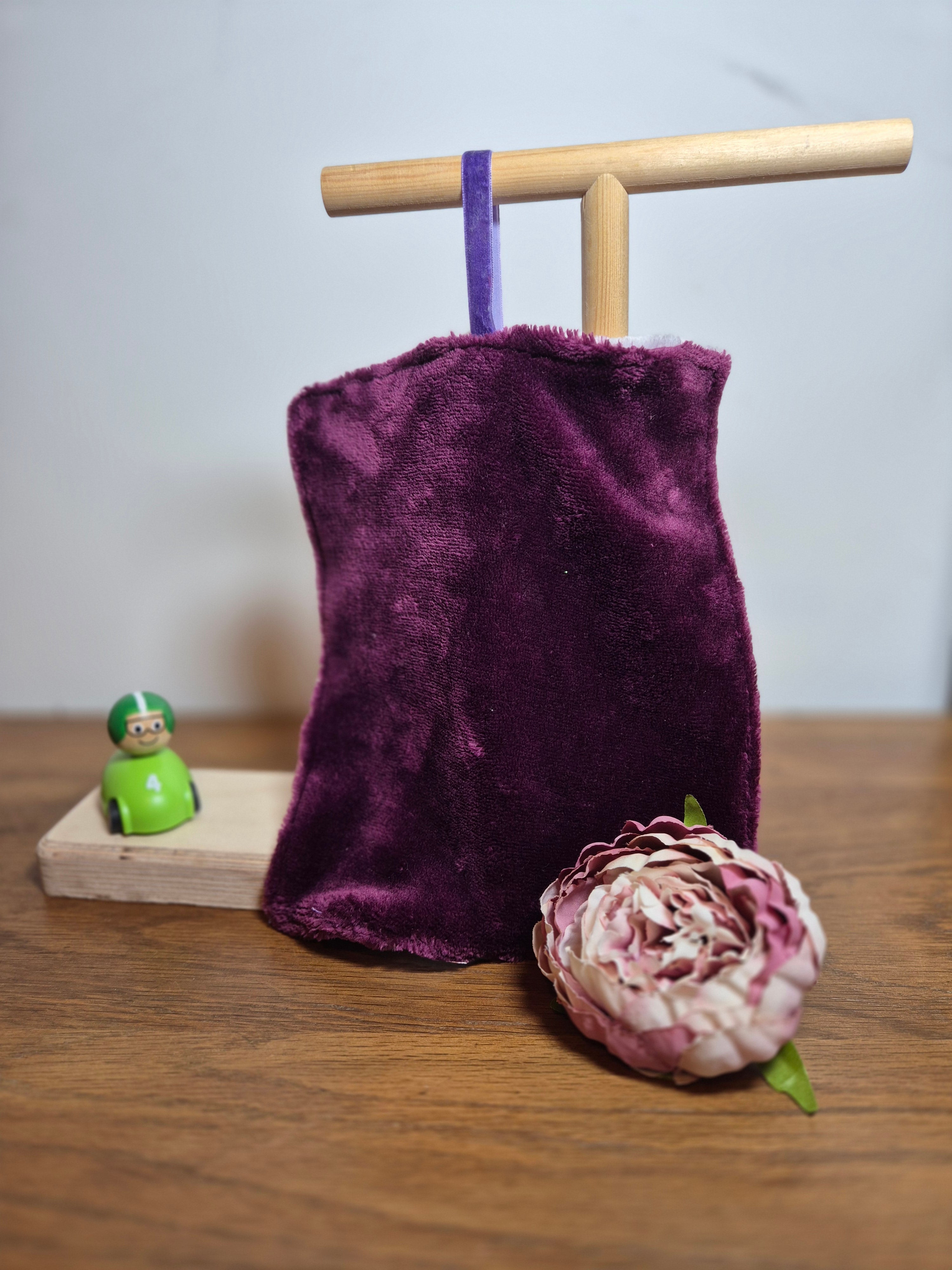 Plain side of fleece comforter on stand with flower and toy accent