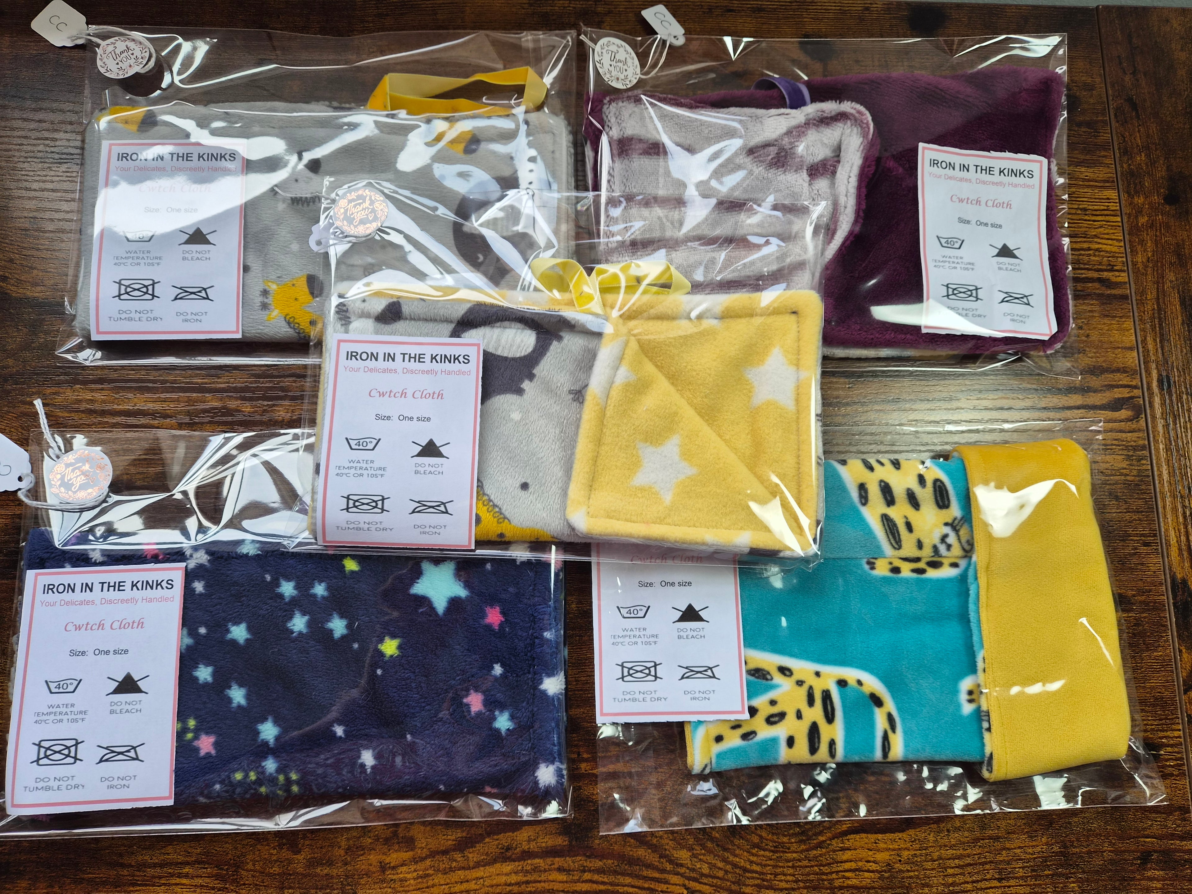 Group photo of the different patterns available of cwtch cloths. 