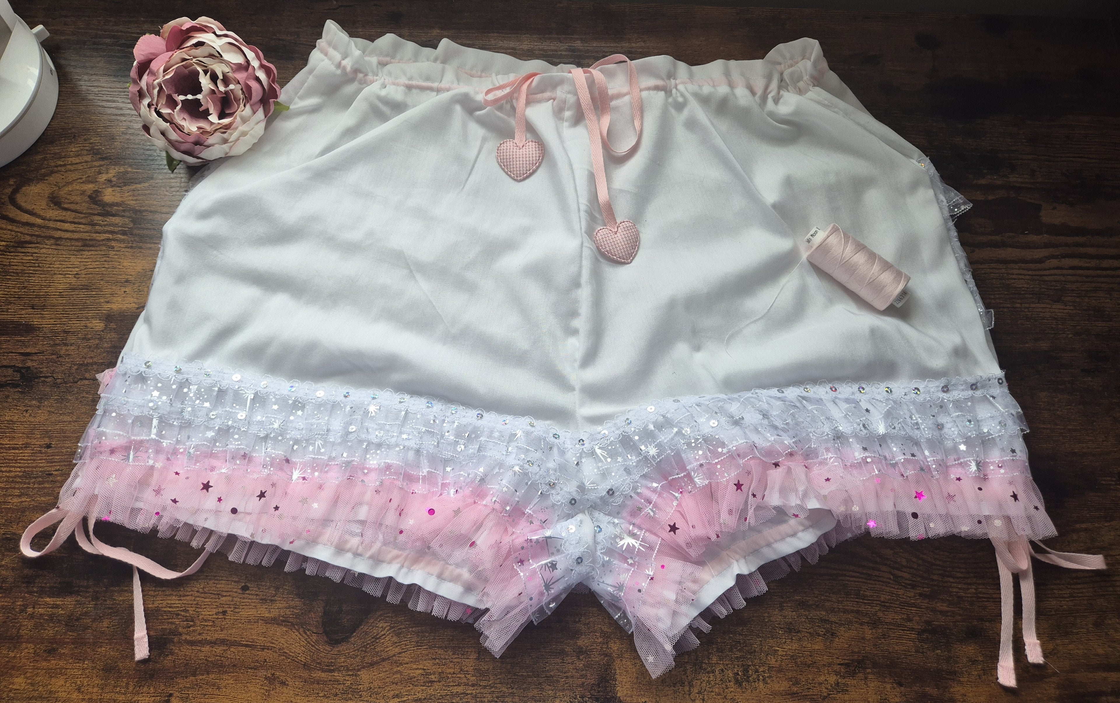 White shorts with pink lace trim on a wooden surface - sissy knickers, adult baby nappy cover, victorian style drawers, unisex