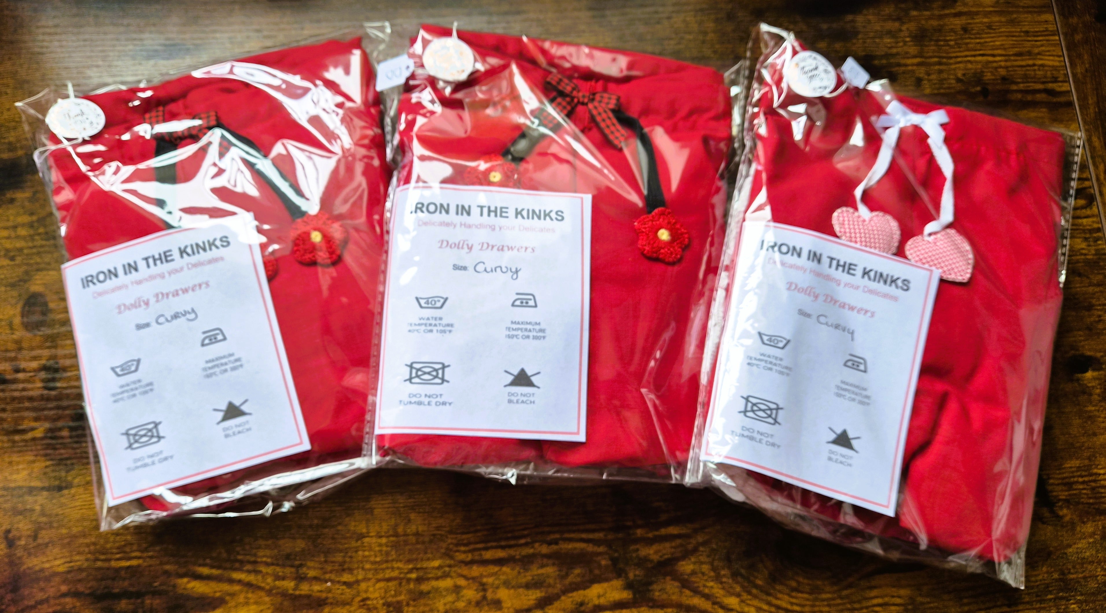 Three packed finished products - red shorts, two with black ties and one with white. All 3 sized curvy with iron in the kinks label.  sissy knickers, adult baby nappy cover, victorian style drawers, unisex