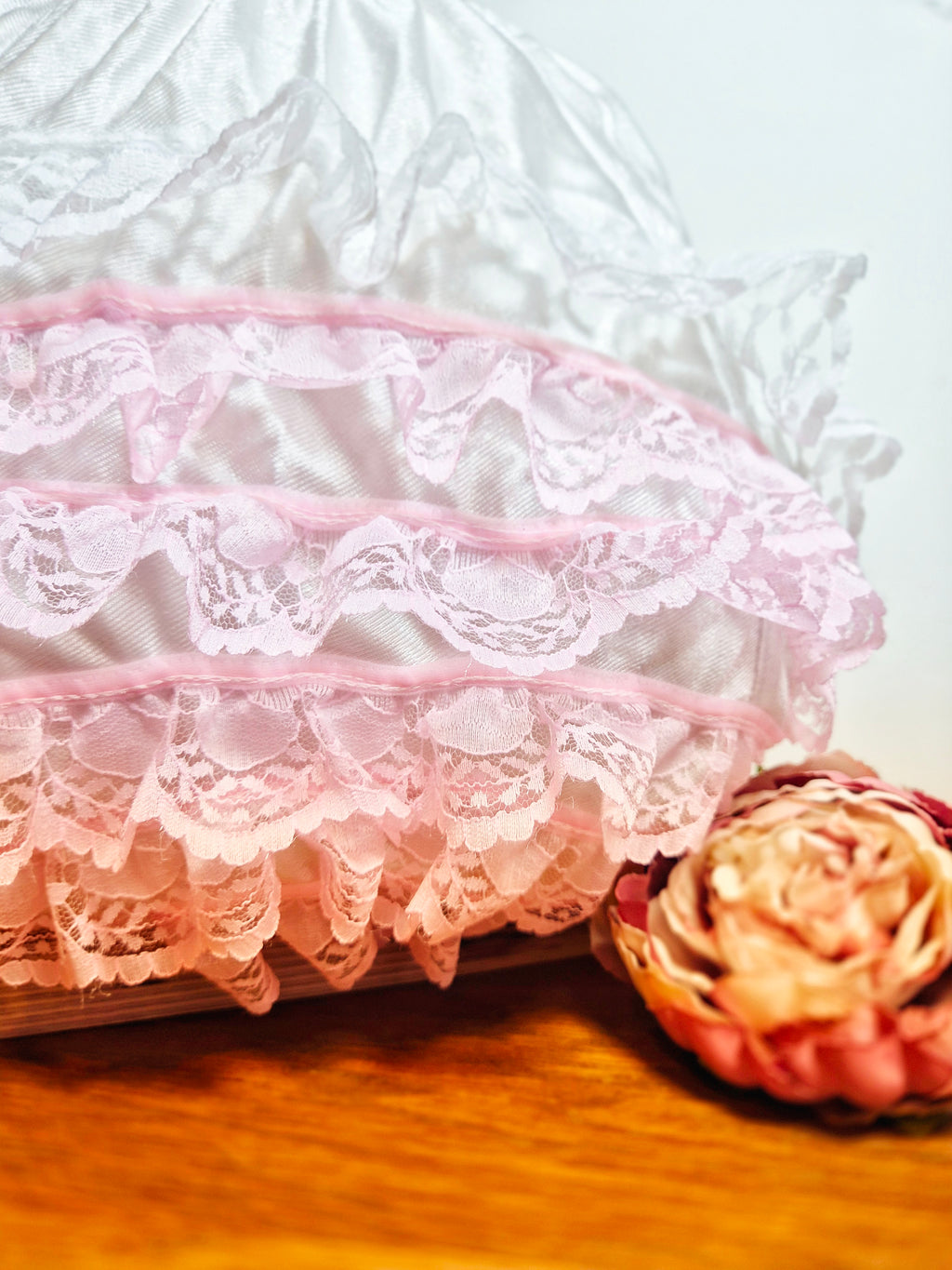Close-up of Kitty Nylon Knickers showing layered white and pink lace ruffle trim  detail and fabric rose