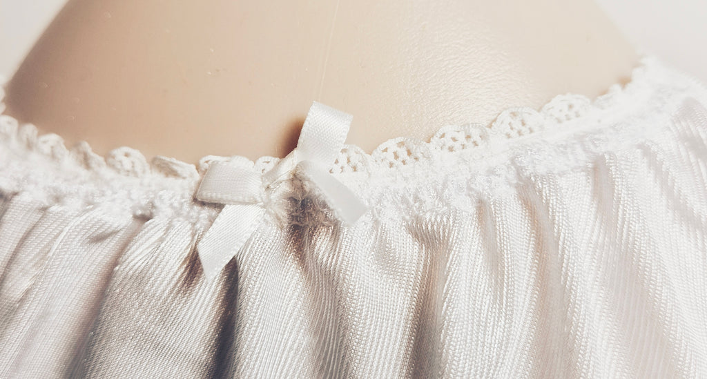Close up of elasticated waist on Kitty Nylon knickers with white ribbon bow. 