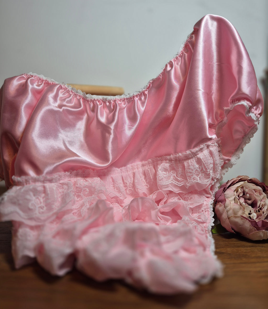 Pink satin panties draped over a stand with pink double layer lace across the back