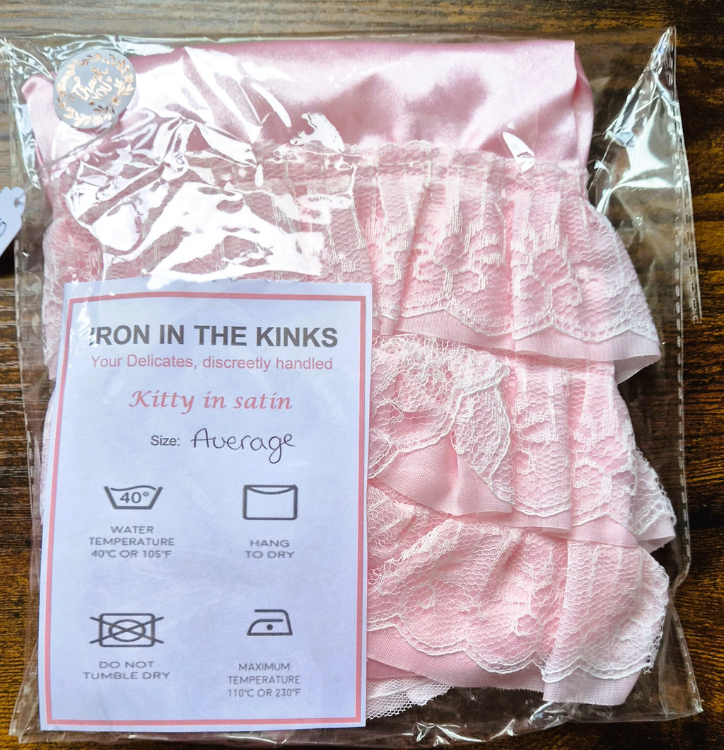 Pink satin panties with double layer pink lace wrapped in celophane with care instructions. 