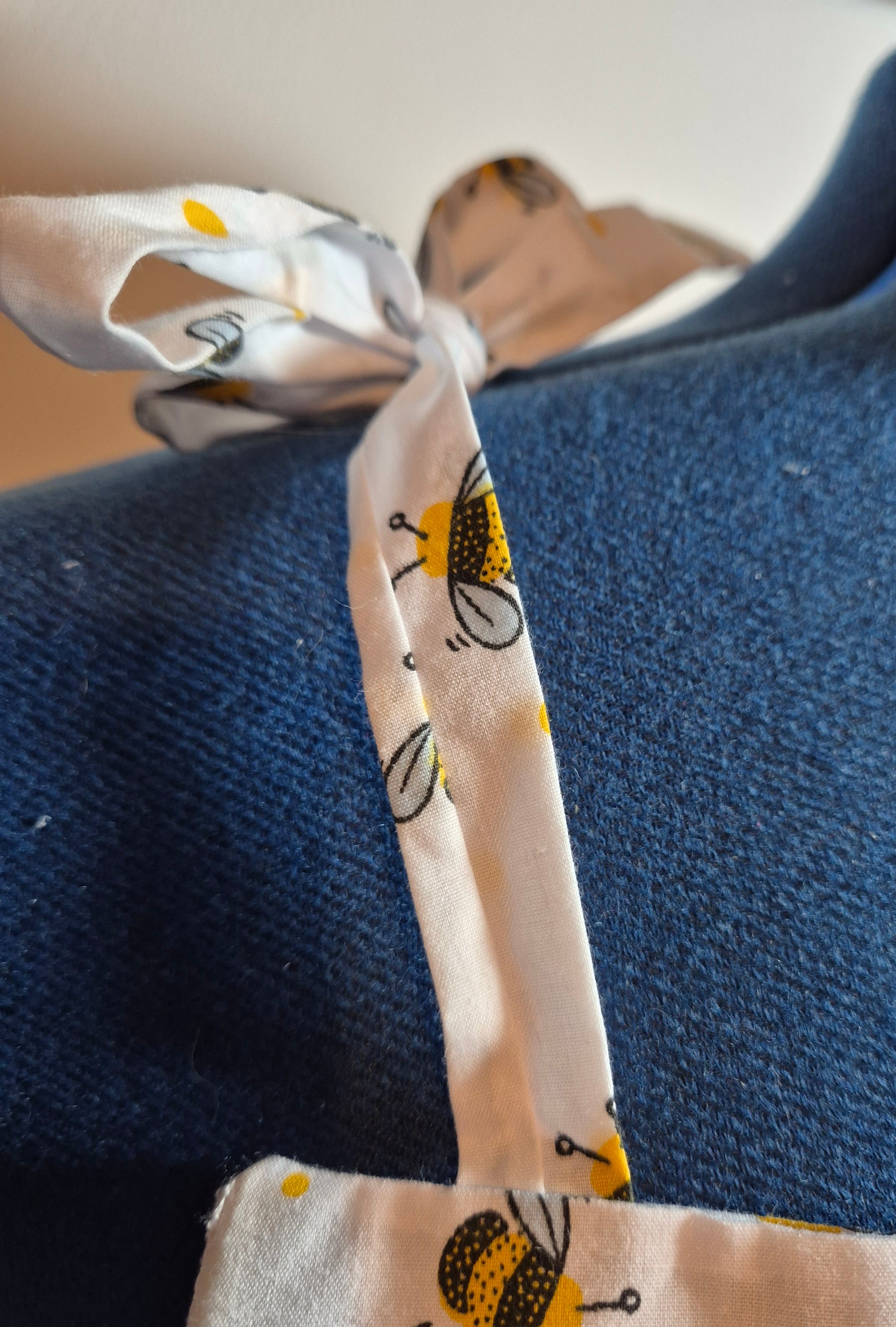 Close-up of a fabric tie with bee pattern on a blue background