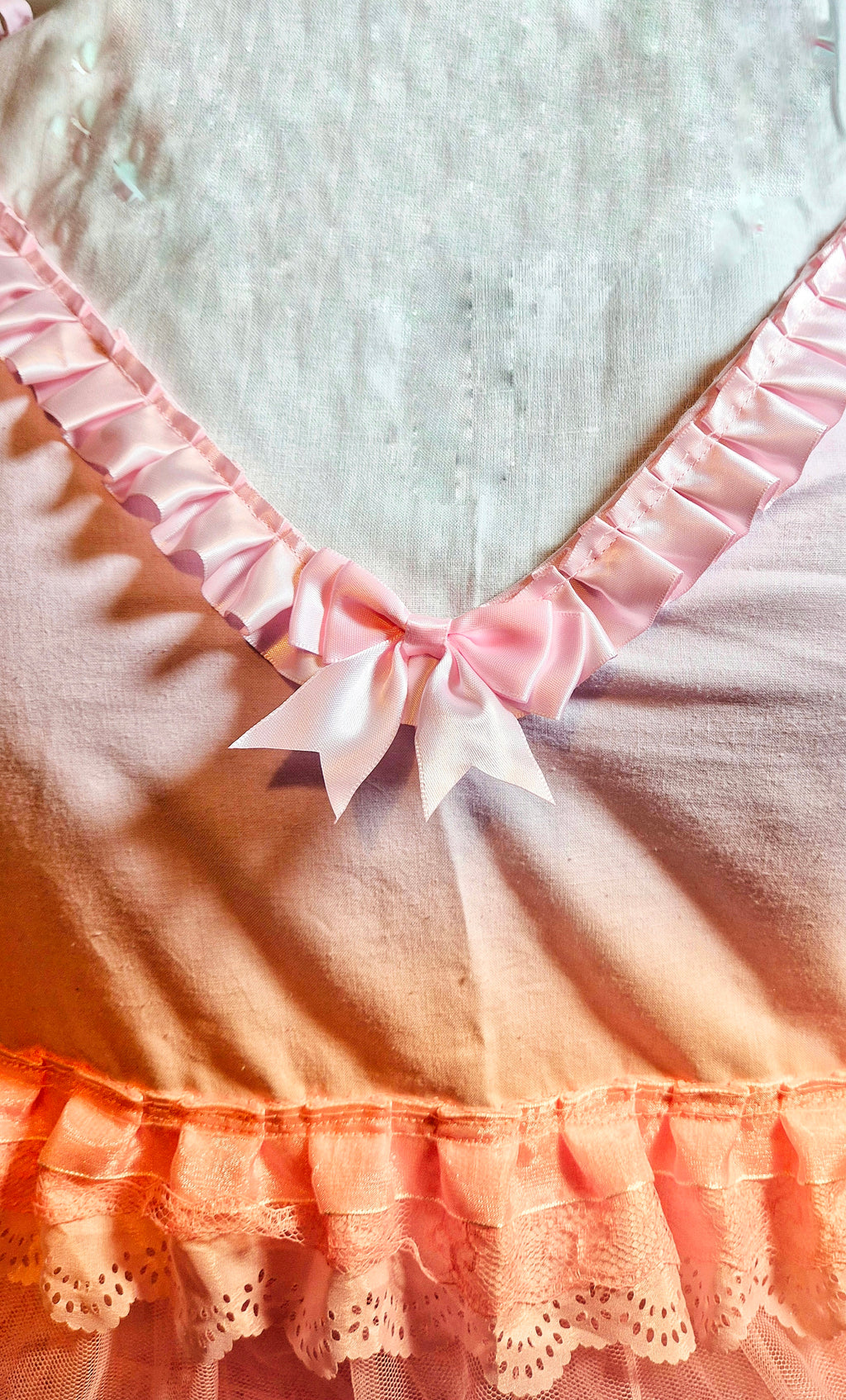 Close-up of Tilly Vintage Style Cami Top V-neckline showing pink satin pleated ruffle trim and central satin bow detail