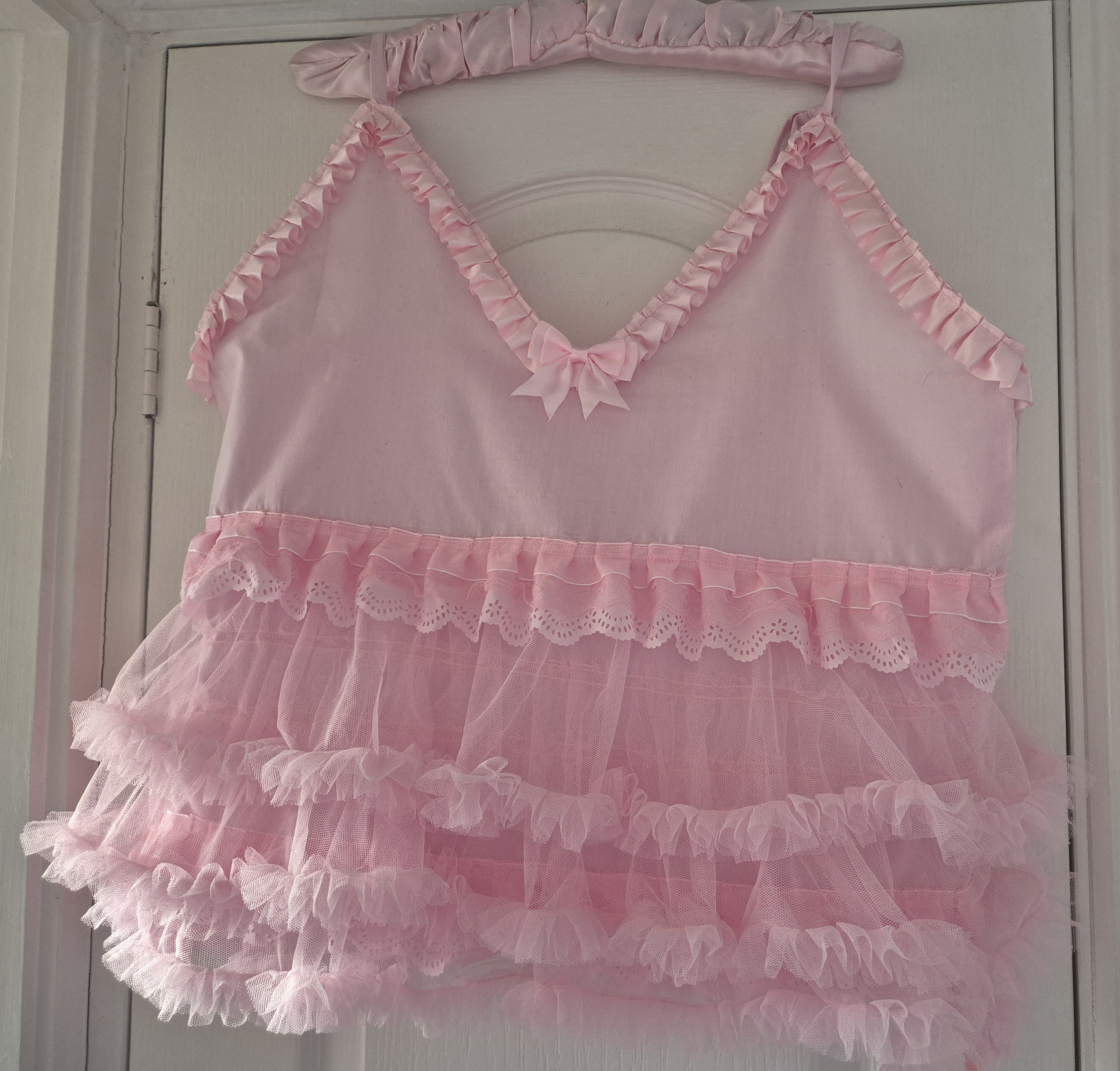 Front view of Tilly Vintage Style Cami Top in white with V-neckline, broderie anglaise trim, pink satin bows and tiered tulle hem